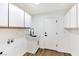 Functional laundry room with sink, cabinets, and wood-look floors at 4117 Sinew Ct, Las Vegas, NV 89129