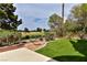 Beautiful backyard with lush lawn, mature trees, and view of the golf course beyond the wrought iron fence at 42 Gulf Stream Ct, Las Vegas, NV 89113