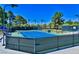Well-maintained tennis courts with a net and perimeter fencing are shown on a bright, sunny day at 42 Gulf Stream Ct, Las Vegas, NV 89113