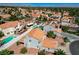 Aerial view showcasing the home, its tile roof, the landscaped backyard, and the neighborhood's lush surroundings at 5 Tarryall Ter, Henderson, NV 89074