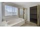 Clean bathroom features a bathtub, glass enclosed shower, and a walk in closet at 5 Tarryall Ter, Henderson, NV 89074