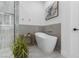 Modern white freestanding bathtub with gold fixtures and neutral tile at 5225 Villa Dante Ave, Las Vegas, NV 89141