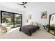 Bright bedroom features a ceiling fan, neutral carpet, and large glass doors to let the sunshine in at 5225 Villa Dante Ave, Las Vegas, NV 89141