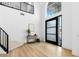 Bright entryway features a high ceiling, modern staircase, sleek black door, and wood-look flooring at 5225 Villa Dante Ave, Las Vegas, NV 89141