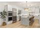 Modern kitchen featuring stainless steel appliances, white cabinets, and a marble waterfall island with seating at 5225 Villa Dante Ave, Las Vegas, NV 89141