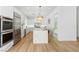 Bright kitchen with stainless steel appliances, white cabinets, marble island, and wood flooring at 5225 Villa Dante Ave, Las Vegas, NV 89141