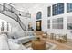 Bright living room with large windows, a staircase, and comfortable sofa at 5225 Villa Dante Ave, Las Vegas, NV 89141