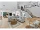 Bright, open-concept living room with white interiors and modern staircase at 5225 Villa Dante Ave, Las Vegas, NV 89141