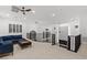 Upstairs loft with a blue sofa, ceiling fan, and black railings with statement windows at 5225 Villa Dante Ave, Las Vegas, NV 89141