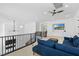 Upstairs loft with a blue sofa, ceiling fan, and black railings with a view of another room at 5225 Villa Dante Ave, Las Vegas, NV 89141
