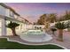 Backyard pool and hot tub with palm trees, surrounded by desert landscaping at twilight at 5225 Villa Dante Ave, Las Vegas, NV 89141