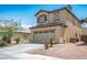 Side view of a charming two-story home with a two car garage, and desert landscaping at 53 Hoke Edward Ct, North Las Vegas, NV 89031