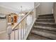 Carpeted staircase featuring white banister and rail leading to the second level with a view of the dining area at 53 Hoke Edward Ct, North Las Vegas, NV 89031