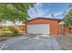 Single-story home with a driveway leading to an attached garage and mature trees at 5317 Holmby Ave, Las Vegas, NV 89146