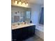 Bathroom with double sinks, vanity, soaking tub, and glass-enclosed shower at 5466 Scotch Cap Dr, Las Vegas, NV 89122