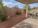 Backyard features a patio, brick accents, rock landscaping, and mature foliage at 5653 Nobleton Ct, North Las Vegas, NV 89081