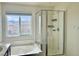 Bright bathroom features a soaking tub, separate shower, and window with neighborhood views at 5653 Nobleton Ct, North Las Vegas, NV 89081