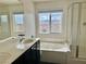 Bright bathroom with double vanity, soaking tub, shower with glass door and a window with neighborhood views at 5653 Nobleton Ct, North Las Vegas, NV 89081