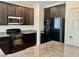 Stylish kitchen with black appliances, dark cabinets, granite countertops, and a built-in wine rack at 5653 Nobleton Ct, North Las Vegas, NV 89081