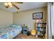 This cozy bedroom features warm wood-look flooring, a ceiling fan, and a comfortable bed with bright accents at 5710 E Tropicana Ave # 2218, Las Vegas, NV 89122