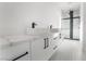 Bathroom featuring a double sink vanity with white countertops and a modern glass enclosed shower at 60 Pecos St, Las Vegas, NV 89110