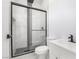 Modern bathroom shower with sleek black fixtures, a glass door, and stylish black and white tiling at 60 Pecos St, Las Vegas, NV 89110