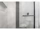 Modern shower with glass door and sleek black hardware accented by patterned tiling and a built in shelf at 60 Pecos St, Las Vegas, NV 89110