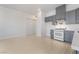 Modern kitchen featuring gray cabinets, quartz countertops, stainless steel appliances, and wood flooring at 60 Pecos St, Las Vegas, NV 89110