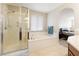 Bright bathroom featuring walk-in shower, soaking tub, and view to the main bedroom at 623 Blue Snow River Ct, Henderson, NV 89002