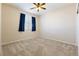 Bedroom featuring carpeted floors, ceiling fan, and large window with dark blue curtains at 623 Blue Snow River Ct, Henderson, NV 89002
