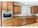 A kitchen features stainless steel appliances, granite countertops, and wood cabinets at 623 Blue Snow River Ct, Henderson, NV 89002
