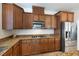 A well-equipped kitchen with granite countertops, stainless steel appliances, and wood cabinets at 623 Blue Snow River Ct, Henderson, NV 89002