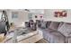 Open concept living room with plush seating, ceiling fan and wood look floors at 628 Carlos Julio Ave, North Las Vegas, NV 89031