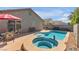 Backyard pool and jacuzzi with poolside seating on concrete pavers on a sunny day at 628 Carlos Julio Ave, North Las Vegas, NV 89031