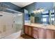 Bright bathroom with double sink vanity, framed mirror, and shower-tub combo with sliding glass door at 6540 Angel Mountain Ave, Las Vegas, NV 89130