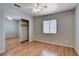 Bedroom featuring laminate flooring, ceiling fan, and mirrored sliding-door closet at 6540 Angel Mountain Ave, Las Vegas, NV 89130