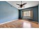 Bedroom with blue walls, ceiling fan, window, and wood laminate flooring at 6540 Angel Mountain Ave, Las Vegas, NV 89130