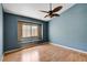 A bedroom featuring blue walls, a window, and wood laminate flooring at 6540 Angel Mountain Ave, Las Vegas, NV 89130
