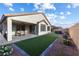 Inviting backyard with a covered patio, artificial grass, and a relaxing hot tub at 6557 Corsari Ridge St, Las Vegas, NV 89166