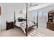 Serene main bedroom featuring a four-poster bed, plantation shutters, and neutral décor at 6557 Corsari Ridge St, Las Vegas, NV 89166