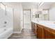 Bright bathroom showcasing a tub/shower, large vanity with double sinks, and access to the bedroom at 6743 Windingwood St, Las Vegas, NV 89148