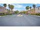 Community entrance gate with palm trees, landscaping, and mountain views at 6743 Windingwood St, Las Vegas, NV 89148
