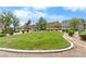Community greenspace with manicured lawns, shrubs, and a walking path on a sunny day at 6743 Windingwood St, Las Vegas, NV 89148