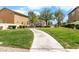 Lush community greenspace featuring a curving sidewalk, trimmed bushes and shady trees at 6743 Windingwood St, Las Vegas, NV 89148