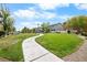 Curving sidewalk through a well-maintained community greenspace with manicured lawns and mature trees at 6743 Windingwood St, Las Vegas, NV 89148