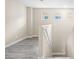 Upstairs hallway featuring gray laminate flooring, natural light, and staircase leading to the lower level at 6743 Windingwood St, Las Vegas, NV 89148