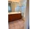 Bathroom featuring double sinks with wood cabinets and a shower with glass doors at 7351 San Pablin St, Las Vegas, NV 89139