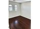 Bright bedroom featuring hardwood floors, white trim, and natural light from two arched windows at 7351 San Pablin St, Las Vegas, NV 89139