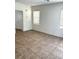 Bright living area with tiled floors, white walls, and natural light from two windows at 7351 San Pablin St, Las Vegas, NV 89139