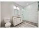 Modern bathroom featuring a glass shower with stone flooring and a white vanity with a granite countertop at 7760 Haven St, Las Vegas, NV 89123